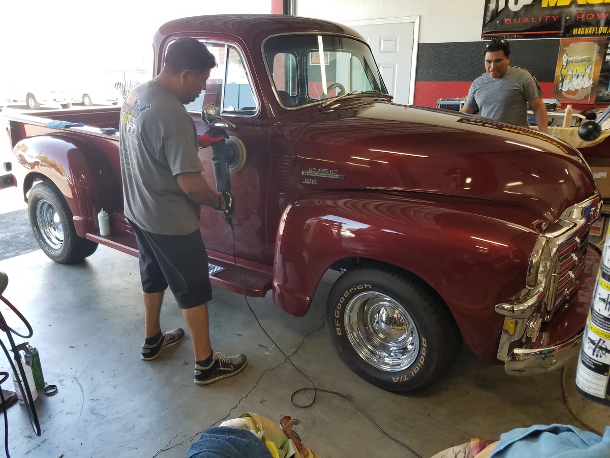 Ruben polishing a classic GMC pickup truck at Ruben's Precision Automotive