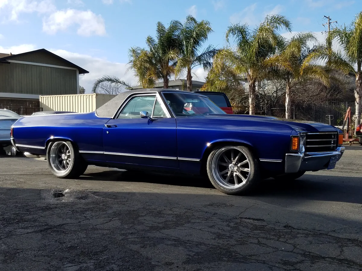 Bright blue Pontiac with custom wheels at the shop