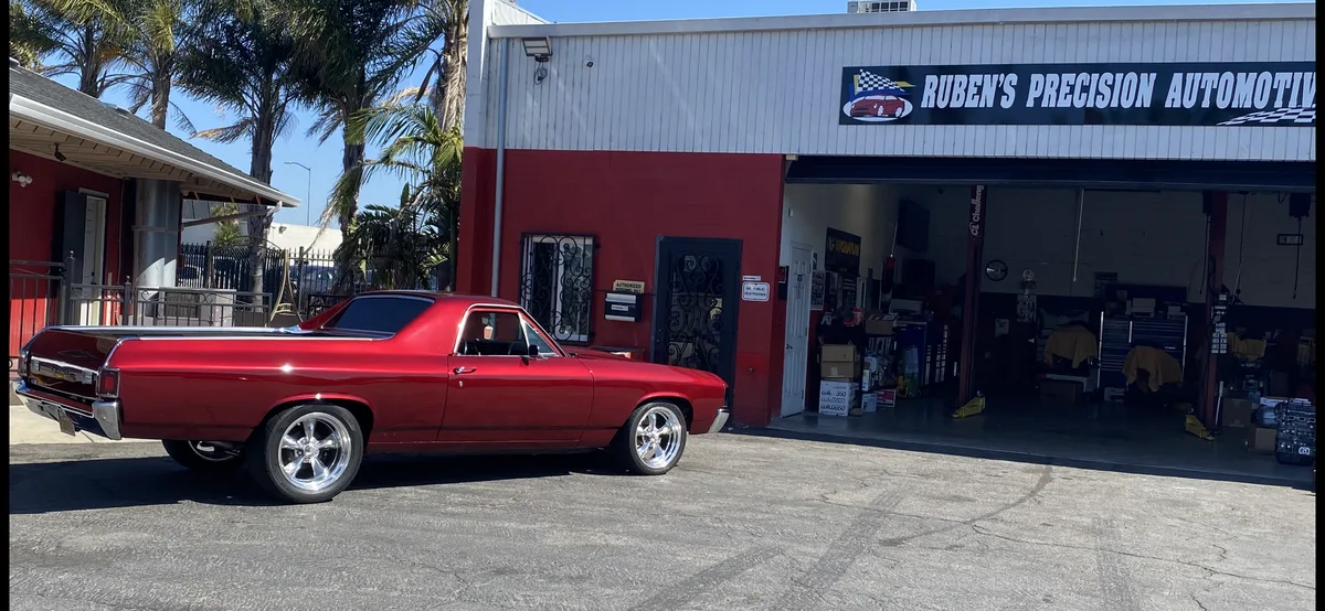 Red 1950s classic sedan with custom wheels at shop